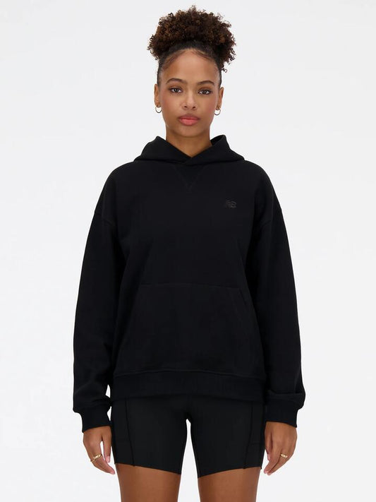 Image of a model wearing Outerwear. Productname: New Balance Athletics French Terry Hoodie in Black colour by brand - New Balance