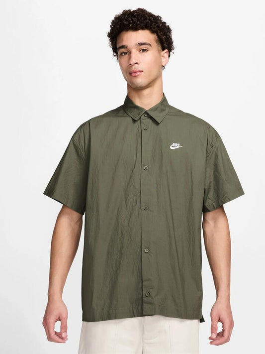 Image of a model wearing Tops. Productname: Nike Club SS OS Shirt in Medium Olive colour by brand - Nike