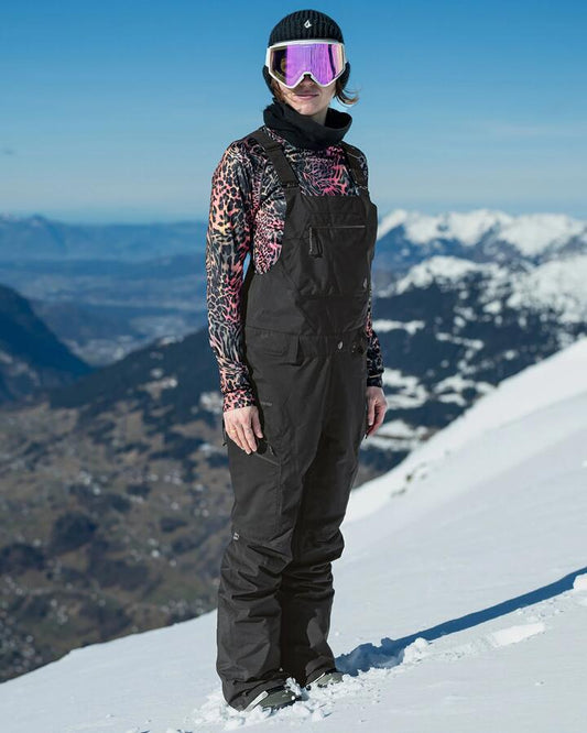 Image of a model wearing Pants. Productname: Volcom Womens Elm Stretch Gore Bib Snow Pants Black - in Black colour by brand - Volcom