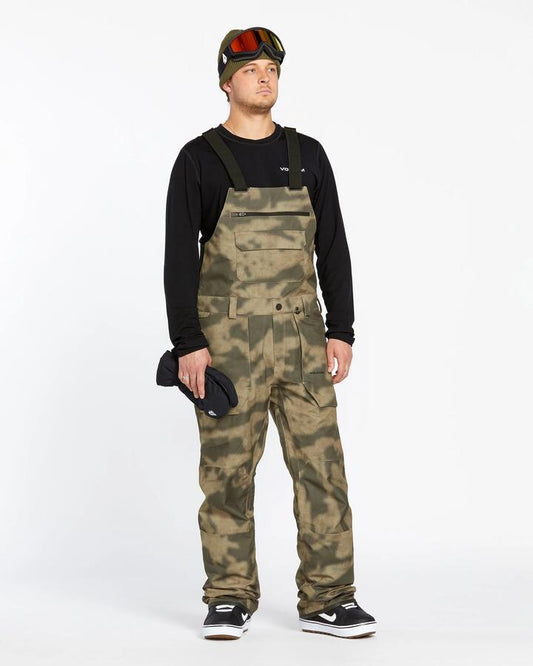 Image of a model wearing Pants. Productname: Volcom - Mens Roan Bib Snow Pants - Camouflage - in Camouflage colour by brand - Volcom