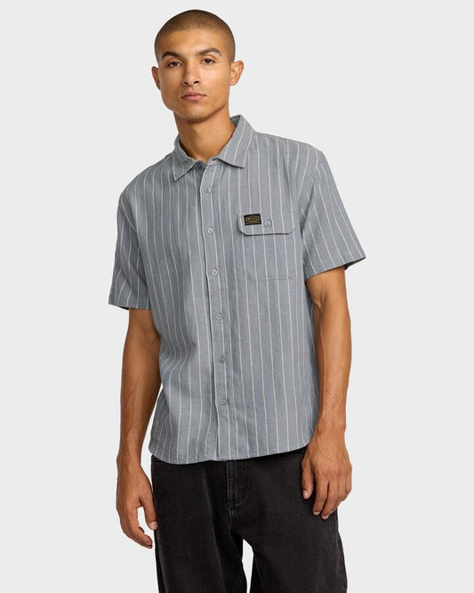 Image of a model wearing Tops. Productname: RVCA Mens Dayshift Stripe Short Sleeve Shirt Chambray - in Chambray colour by brand - RVCA