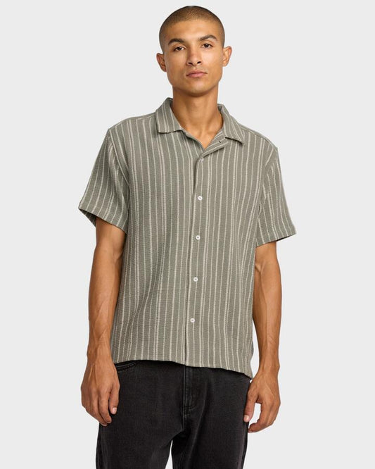 Image of a model wearing Tops. Productname: RVCA Mens Vacancy Stripe Short Sleeve Shirt Light Olive - in Light Olive colour by brand - RVCA