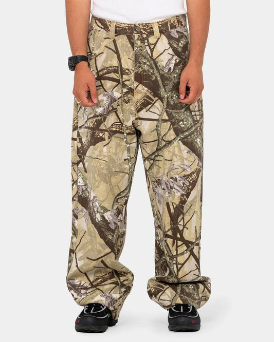 Image of a model wearing Pants. Product name - Rusty Mens Hoodus Rambo Baggy Pants Camo in Camo colour by brand - Rusty
