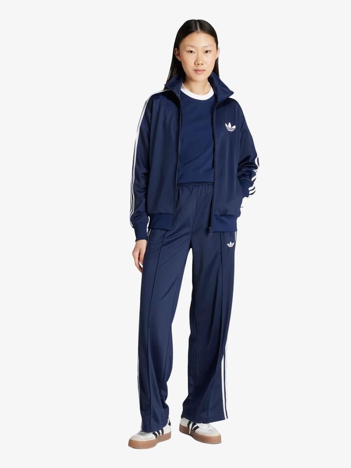 Image of a model wearing Pants. Productname: Adidas Women's Firebird Track Pants in night indigo/white colour by brand - Adidas