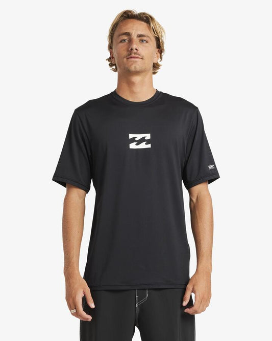 Image of a model wearing Tops. Product name - Billabong Mens All Day Wave Short Sleeve Rash Vest Black in Black colour by brand - Billabong