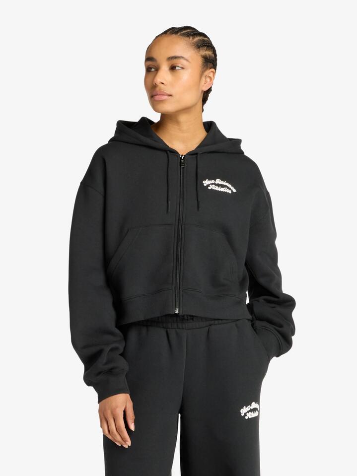 Image of a model wearing Outerwear. Productname: New Balance Linear Heritage Fleece Full Zip in Black colour by brand - New Balance