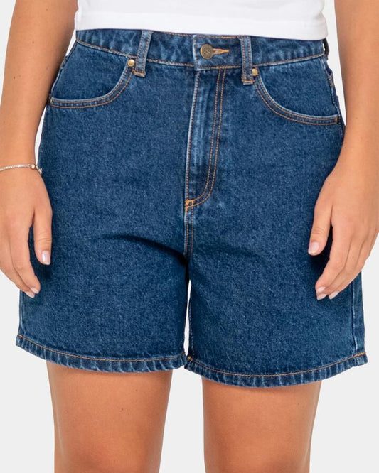 Image of a model wearing Shorts. Productname: Rusty - Womens Cyprus High Denim Shorts - Deep Sea Blue - in Deep Sea Blue colour by brand - Rusty