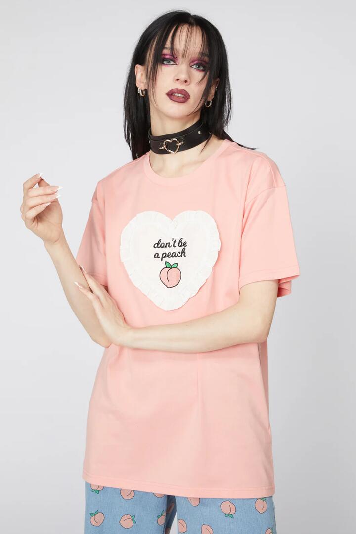 Image of a model wearing Tops. Productname: Peach Applique Cotton Tee in Peach colour by brand - Dangerfield