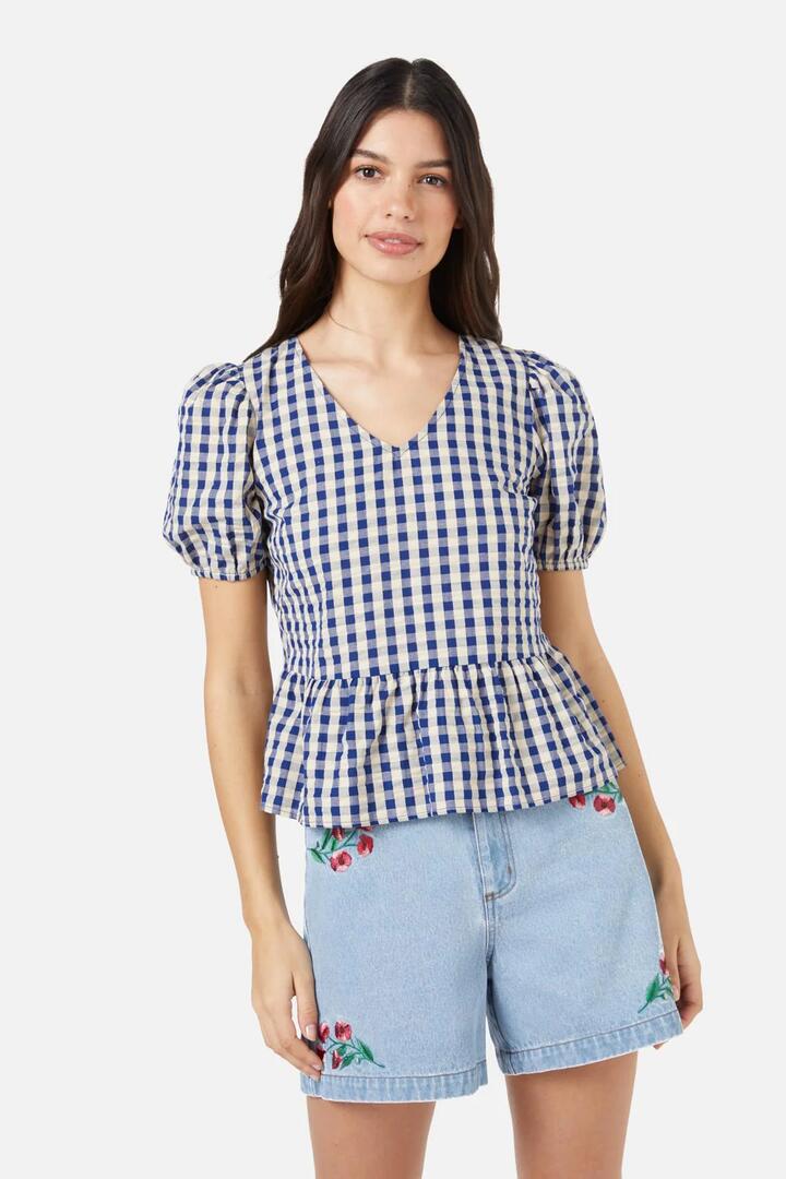 Image of a model wearing Tops. Productname: Greta Check Ruffle Top in Navy colour by brand - Princess Highway