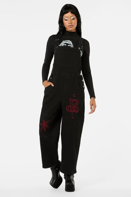 Image of a model wearing Pants. Product name - Grace Embroidered Overalls in Black colour by brand - Black Friday