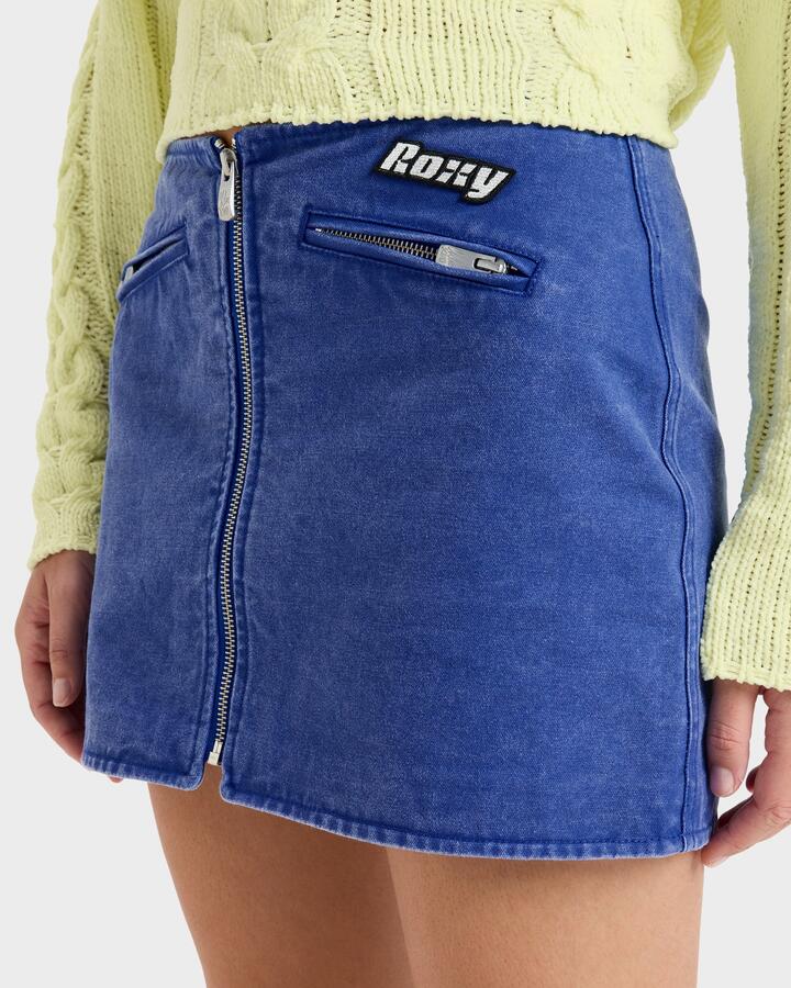 Image of a model wearing Skirts. Productname: Roxy - Womens Chloe Kim Mini Moto Denim Skirt - Dazzling Blue - in Dazzling Blue colour by brand - Roxy