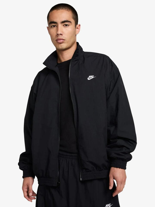 Image of a model wearing Outerwear. Productname: Nike Nike Club Men's Oversized Woven Track Jacket in Black/White colour by brand - Nike
