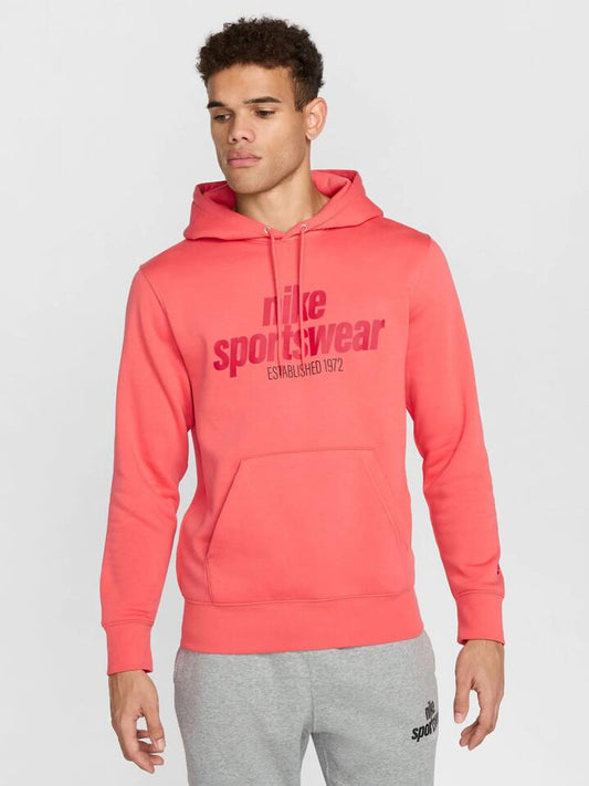 Image of a model wearing Outerwear. Productname: Nike Club Menâs Fleece Pullover Hoodie in Magic Ember colour by brand - Nike