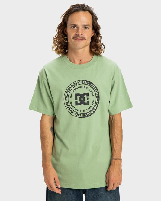 Image of a model wearing Tops. Productname: DC Shoes - Mens Dc Corpo T-Shirt - Basil - in Basil colour by brand - DC Shoes