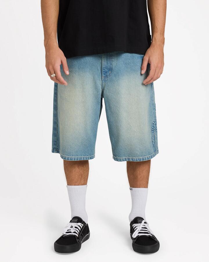 Image of a model wearing Shorts. Product name - Billabong Mens Script Smoko Denim 22" Shorts Sun Faded Indigo - in Sun Faded Indigo colour by brand - Billabong