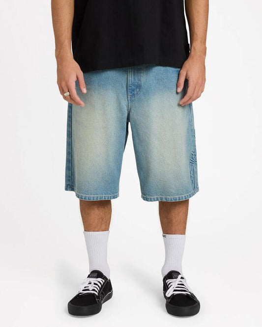 Image of a model wearing Shorts. Product name - Billabong Mens Script Smoko Denim 22" Shorts Sun Faded Indigo - in Sun Faded Indigo colour by brand - Billabong