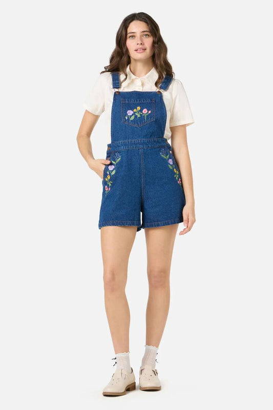 Image of a model wearing Pants. Product name - Flower Patch Embroidered Short Overall in Blue Denim colour by brand - Princess Highway