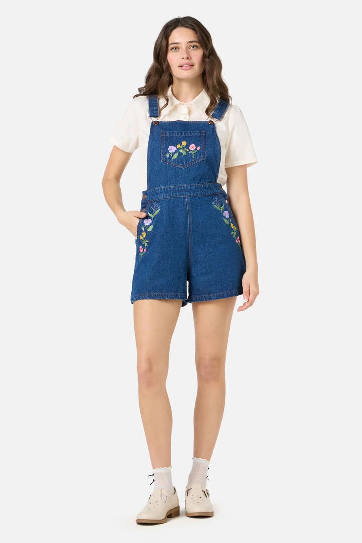 Image of a model wearing Pants. Product name - Flower Patch Embroidered Short Overall in Blue Denim colour by brand - Princess Highway