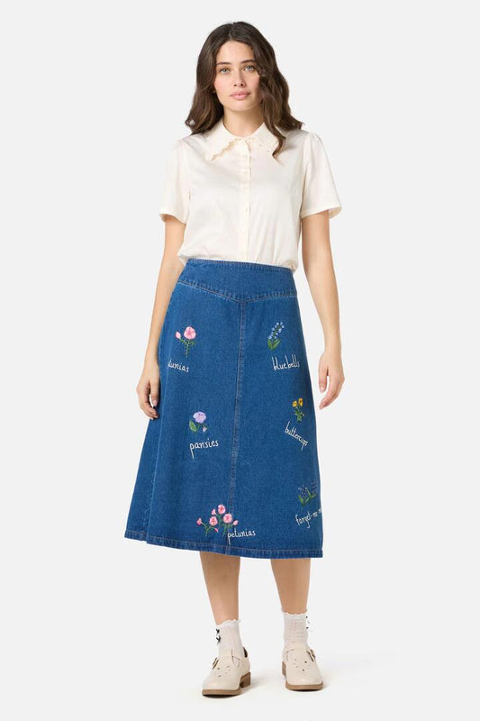Image of a model wearing Skirts. Product name - Flower Patch Embroidered Denim Skirt in Blue Denim colour by brand - Princess Highway