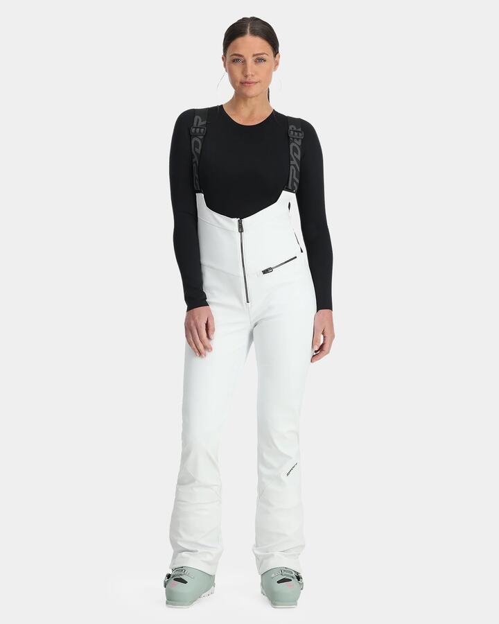 Image of a model wearing Pants. Productname: Spyder - Womens Strutt Bib Softshell Snow Pants - White - in White colour by brand - Spyder