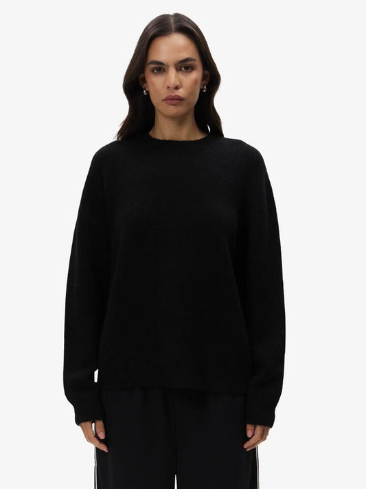 Image of a model wearing Outerwear. Productname: Lulu & Rose Crew Neck Jumper in Black colour by brand - Lulu & Rose