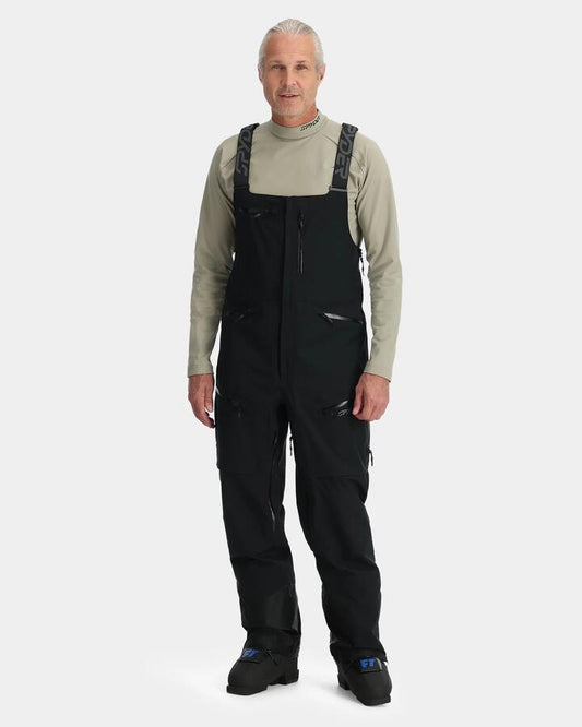 Image of a model wearing Pants. Productname: Spyder - Mens Sanction Bib Shell Snow Pants - Black - in Black colour by brand - Spyder