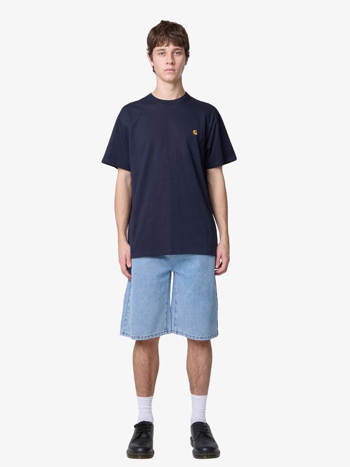 Image of a model wearing Tops. Productname: Carhartt Wip Short Sleeve Chase T-Shirt in Navy/Gold colour by brand - Carhartt Wip