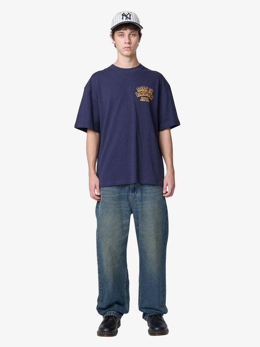 Image of a model wearing Tops. Productname: Deus Reality Wreckers Tee in Navy colour by brand - Deus