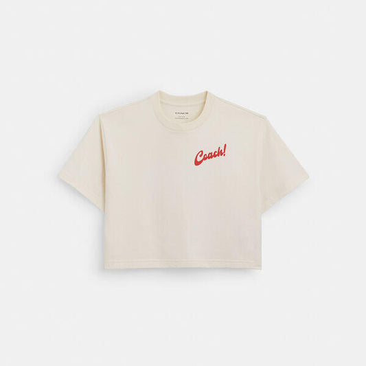 Image of a model wearing Tops. Productname: Boardwalk Cropped T-Shirt In Organic Cotton in CREAM colour by brand - Coach Outlet Australia