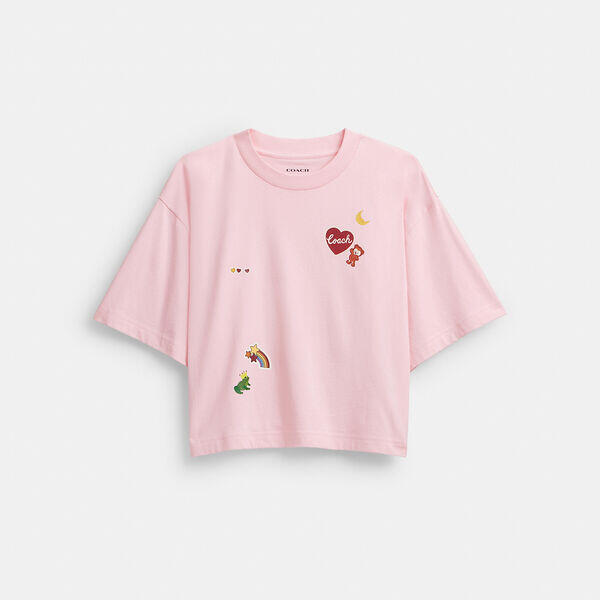 Image of a model wearing Tops. Productname: Cropped T-Shirt In Organic Cotton With Sticker Patches in LIGHT PINK colour by brand - Coach Outlet Australia