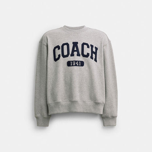 Image of a model wearing Outerwear. Productname: Sporty Signature Boyfriend Crewneck Sweatshirt in HEATHER GREY colour by brand - Coach Outlet Australia
