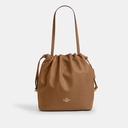 Image of a model wearing Pants. Productname: Faye Drawstring Tote Bag in HONEY BROWN colour by brand - Coach Outlet Australia