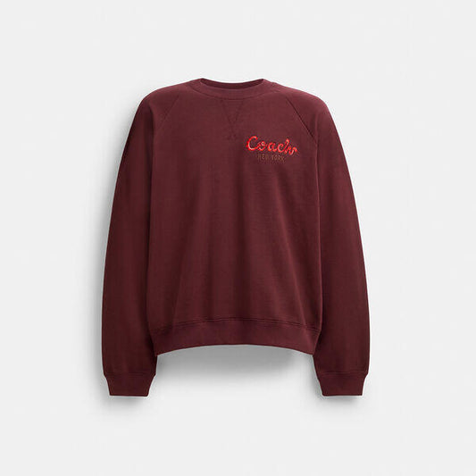 Image of a model wearing Outerwear. Productname: Coach Snake Script Sweatshirt in MERLOT colour by brand - Coach Outlet Australia