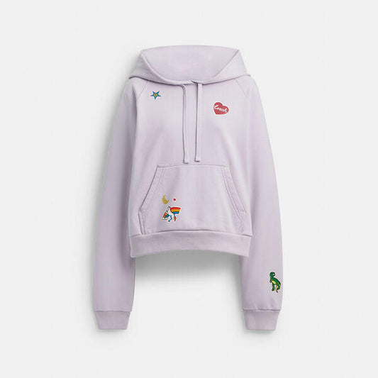 Image of a model wearing Outerwear. Productname: Shrunken Raglan Hoodie With Sticker Patches in LIGHT PURPLE colour by brand - Coach Outlet Australia
