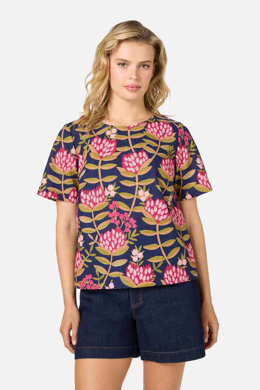 Image of a model wearing Shorts. Productname: Protea Flower Short Sleeve Top in Navy colour by brand - Princess Highway