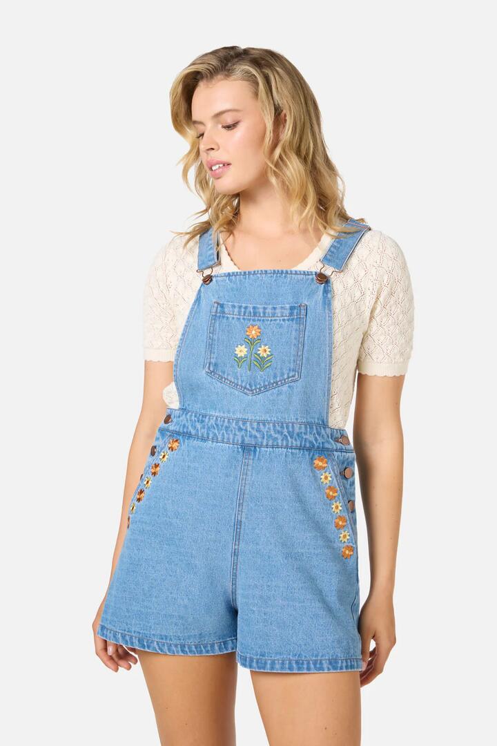 Image of a model wearing Pants. Productname: Cleo Embroidered Short Overall in Blue Denim colour by brand - Princess Highway