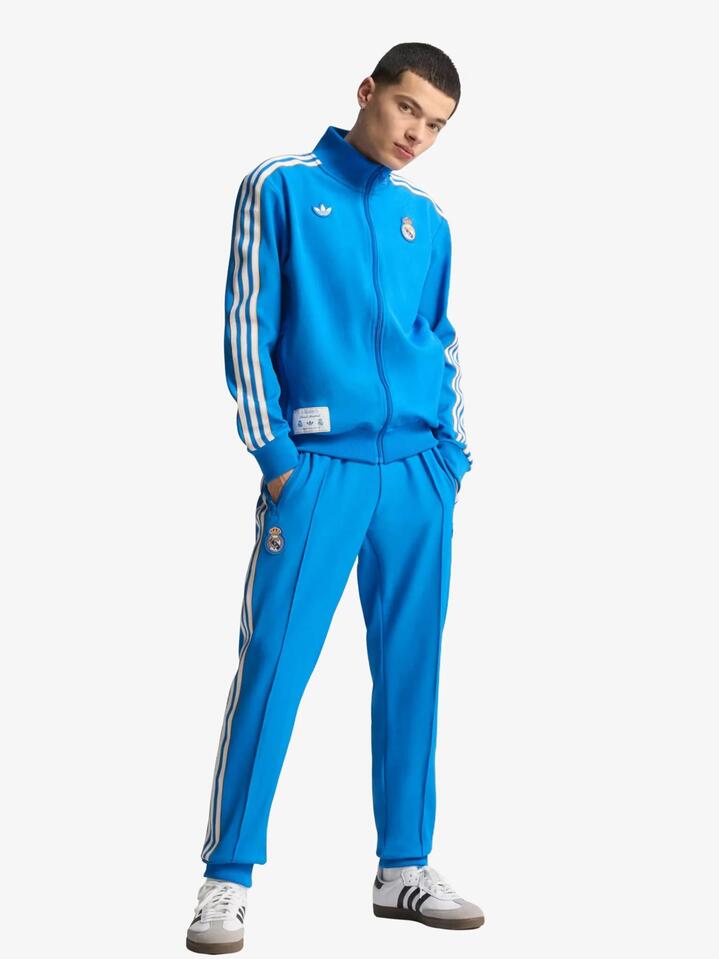 Image of a model wearing Tops. Productname: Adidas Real Icon Track Top in Blue Bird / White colour by brand - Adidas