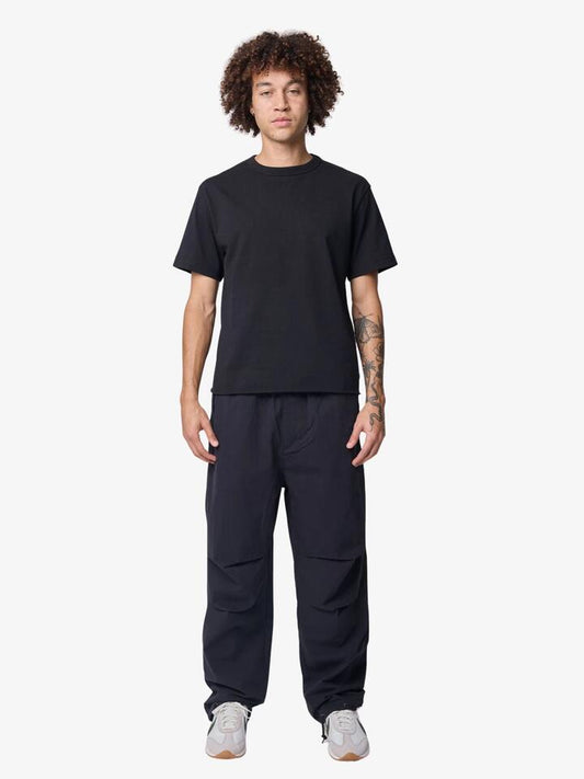Image of a model wearing Pants. Productname: Deus Remi Parachute Pants in Black colour by brand - Deus