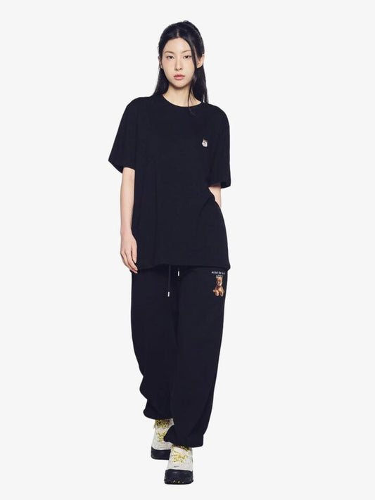 Image of a model wearing Tops. Productname: ADLV Ac Bear Wappen T-Shirt in Black colour by brand - ADLV