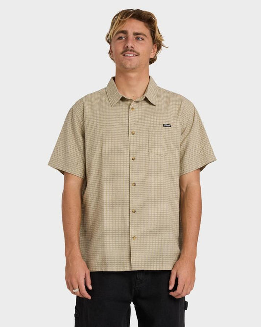 Image of a model wearing Tops. Product name - Billabong Mens Mogul Short Sleeve Shirt Stone in Stone colour by brand - Billabong