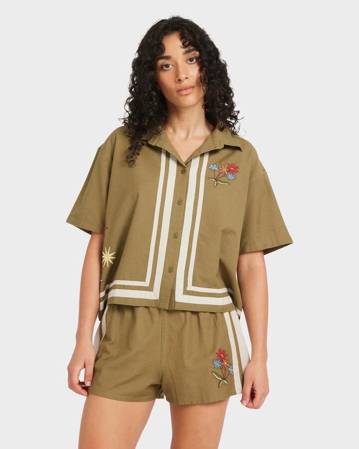 Image of a model wearing Tops. Productname: RVCA - Womens Mel G Button Down Short Sleeve Shirt - Olive - in Olive colour by brand - RVCA