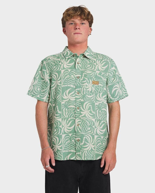 Image of a model wearing Tops. Productname: RVCA Mens Exotica Short Sleeve Shirt Sage Leaf - in Sage Leaf colour by brand - RVCA