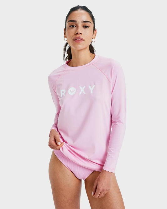 Image of a model wearing Tops. Product name - Roxy Womens Essentials Long Sleeve Rash Vest Bonbon in Bonbon colour by brand - Roxy
