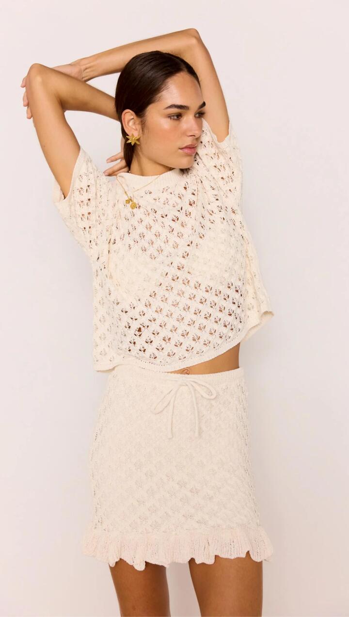 Image of a model wearing Skirts. Product name - White Pointelle Knit Mini Skirt in Ivory colour by brand - MINKPINK