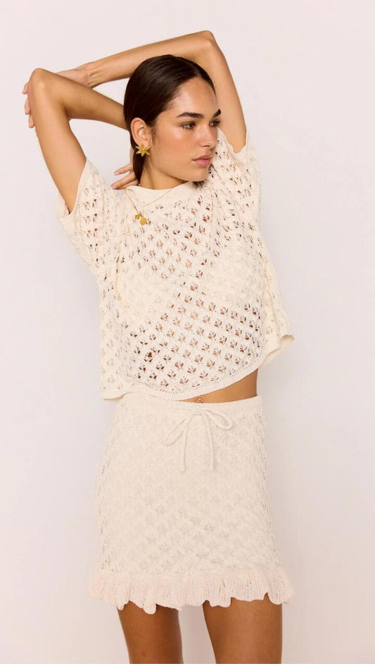 Image of a model wearing Skirts. Product name - White Pointelle Knit Mini Skirt in Ivory colour by brand - MINKPINK