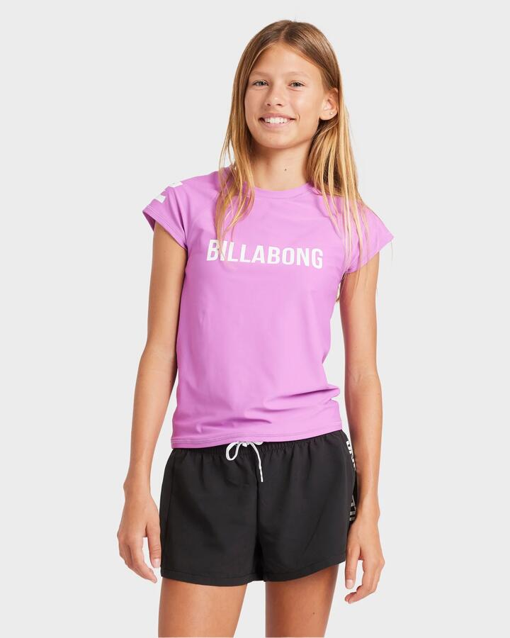 Image of a model wearing Tops. Product name - Billabong Girls 8-16 Short Sleeve Rash Vest Barbados in Barbados colour by brand - Billabong