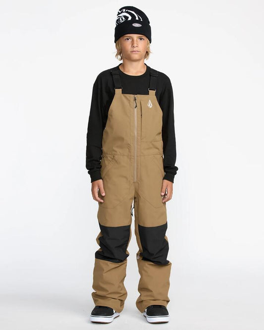 Image of a model wearing Pants. Product name - Volcom Boys 8-16 Barkley Insulated Bib Snow Pants Bronze in Bronze colour by brand - Volcom