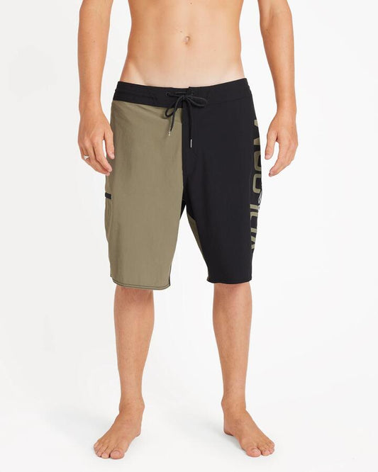 Image of a model wearing Shorts. Product name - Volcom Mens Surf Vitals Noa Deane 21" Boardshort Dark Olive in Dark Olive colour by brand - Volcom
