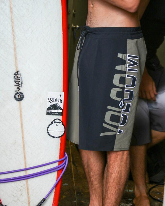 Image of a model wearing Shorts. Product name - Volcom Mens Surf Vitals Noa Deane 21" Boardshort Dark Olive in Dark Olive colour by brand - Volcom