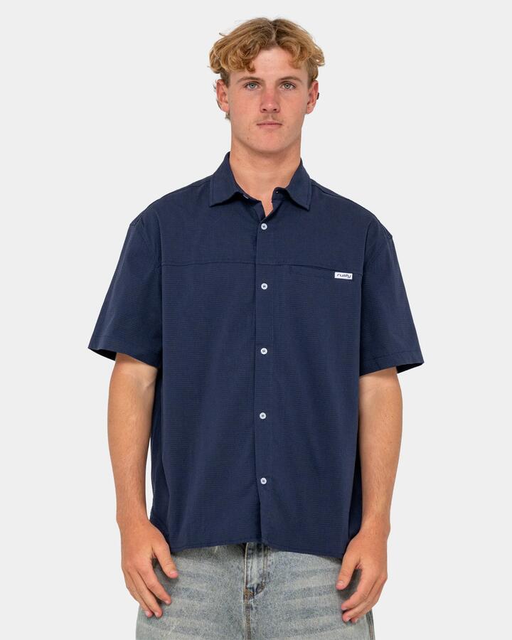 Image of a model wearing Tops. Productname: rusty Mens Giles Short Sleeve Shirt Navy Blue - in Navy Blue colour by brand - Rusty